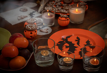table with decorations, candles and sweets for Halloween.