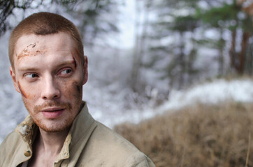 guy with bruises on his face in the winter forest