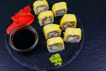 Sushi cheese rolls on a black slate