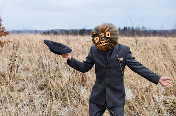 man in a fancy dress celebrates Halloween by taking off his hat in a field as a sign of respect for everyone he meets