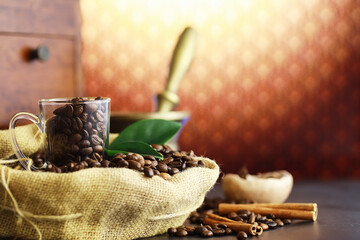 Bag of coffee. Coffee beans roasted on the table. Coffee beans with green leaves for cooking.