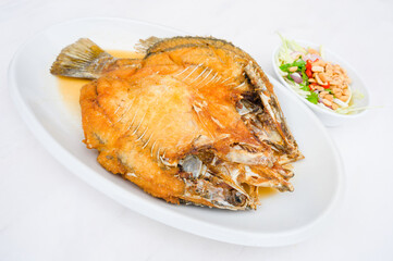 Fried snapper on white plate  with fish sauce
