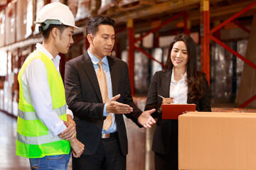 Asian Warehouse manager and male worker as engineer interacting talking checking inventory, manager...