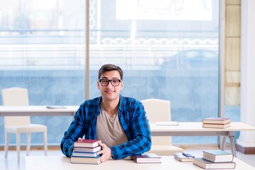 Student studying in the empty library with book preparing for ex