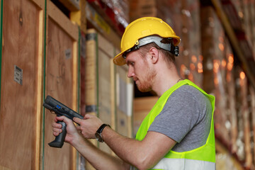 Caucasian warehouse worker using barcode scanner checking stock goods in the store, worker with...