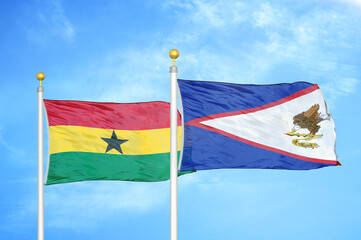 Ghana and American Samoa two flags on flagpoles and blue sky