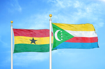 Ghana and Comoros two flags on flagpoles and blue sky