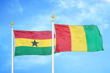 Ghana and Guinea two flags on flagpoles and blue sky