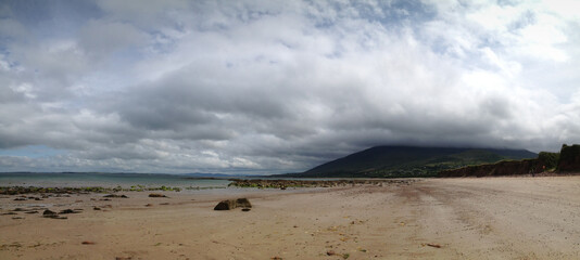 Sandstrand mit Hügel und tiefhängenden Wolken