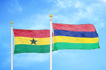 Ghana and Mauritius two flags on flagpoles and blue sky
