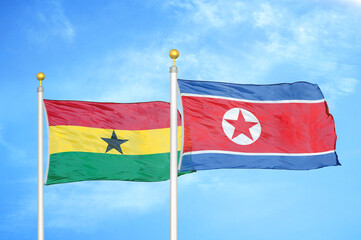 Ghana and North Korea two flags on flagpoles and blue sky