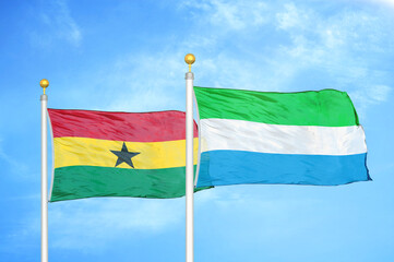 Ghana and Sierra Leone two flags on flagpoles and blue sky