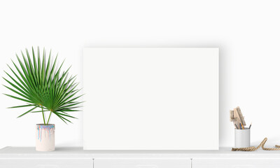 Interior horizontal rectangular poster mockup standing on the table with plant and decorations on empty white wall background. Rendering illustration.