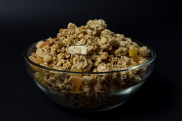 granola in a transparent plate with pieces of tropical fruits