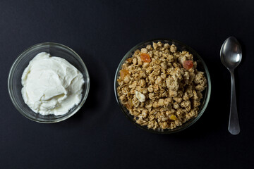 preparing breakfast. yogurt and granola with pieces of tropical fruits in transparent plates