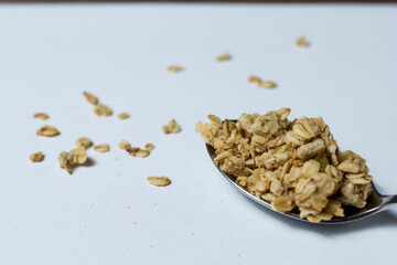 granola in a spoon on a white background.