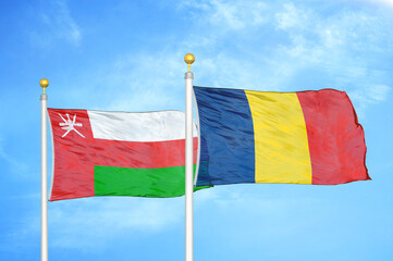 Oman and Chad two flags on flagpoles and blue sky