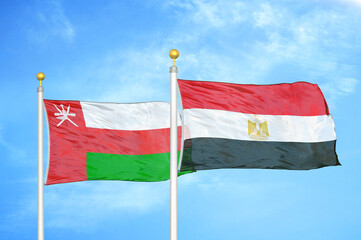 Oman and Egypt two flags on flagpoles and blue sky