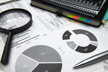 business office desk closeup - financial reports, analysis and accounting, set of documents, tables and graphs, various items for bookkeeping, calculator