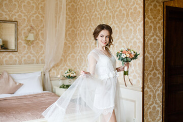 Pretty young Bride.Brown-haired woman with classic wedding hair-style. Boudoir morning of the bride. 