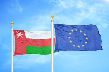 Oman and European Union two flags on flagpoles and blue sky
