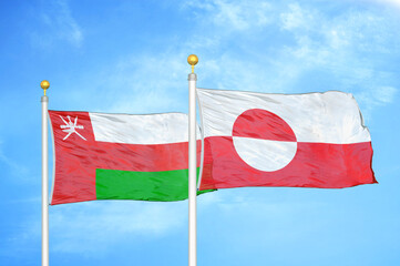 Fototapeta na wymiar Oman and Greenland two flags on flagpoles and blue sky