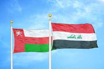 Oman and Iraq two flags on flagpoles and blue sky