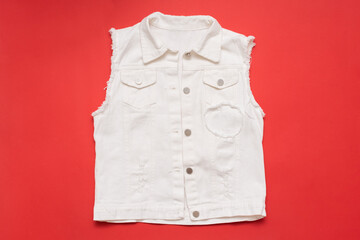 White denim jeans vest on a red background.