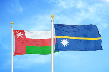 Oman and Nauru two flags on flagpoles and blue sky