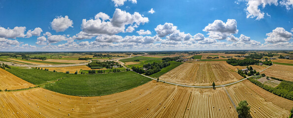 Aerial panorama of rural road passing through agricultural land in Poland countryside