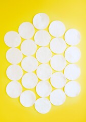 Cotton cotton discs on a yellow background. Personal hygiene and care. Medicine and cosmetology.