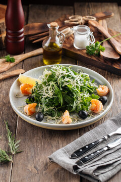 Fresh arugula salad with shrimps and olives