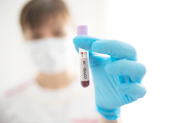 Female nurse holds test tube with blood sample with positive test COVID-19