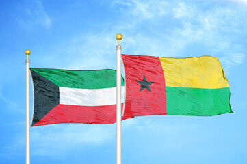 Kuwait and Guinea-Bissau two flags on flagpoles and blue sky