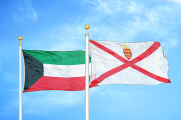 Kuwait and Jersey two flags on flagpoles and blue sky