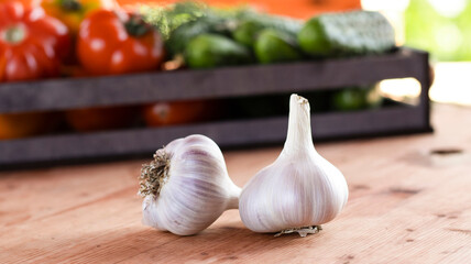 Vegetables tomatoes and cucumbers in a wooden box on a wooden table, close-up. Harvest, garden, vegetable garden. Blurred bokeh background.