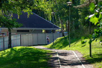 People walking in the city park. Summer landscape in a small town. Great place to walk