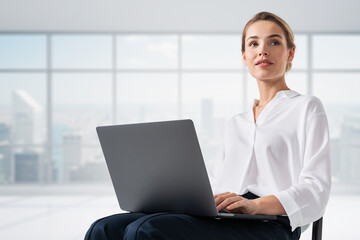 Young businesswoman with laptop in office