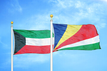 Kuwait and Seychelles two flags on flagpoles and blue sky