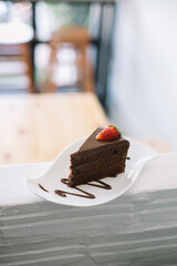 Sliced chocolate cake with fresh strawberries on a white plate.