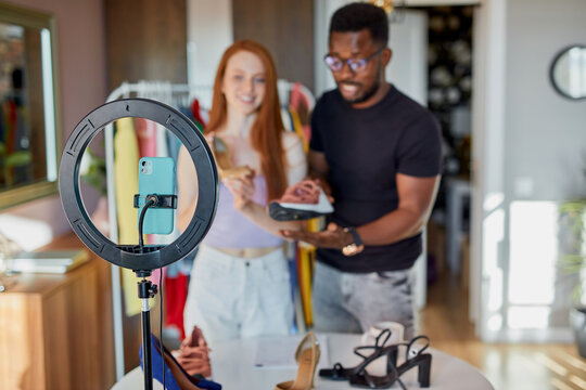 Two Fashion Bloggers Talk At Camera At Home, Young Diverse Man And Woman Broadcast On Camera Together, Give Useful Tips On Combining Things