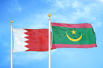 Bahrain and Mauritania two flags on flagpoles and blue sky