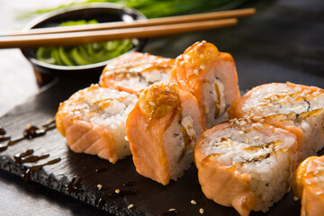 Set of fried sushi rolls with wasabi and ginger on black background. Japanese oriental cuisine