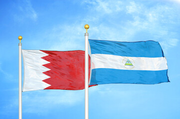 Bahrain and Nicaragua two flags on flagpoles and blue sky