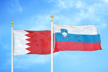 Bahrain and Slovenia two flags on flagpoles and blue sky
