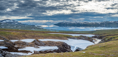 Beautiful Horizontal landscape North of the Arctic Circle in Swedish Lapland overlooking Big lake Vastenjaure on the Padjelanta Trail and The Border to Norway and Fjords reflection in the Water.