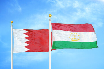 Bahrain and Tajikistan two flags on flagpoles and blue sky