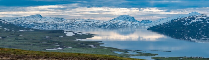 Beautiful Horizontal landscape North of the Arctic Circle in Swedish Lapland overlooking Big lake Vastenjaure on the Padjelanta Trail and The Border to Norway and Fjords reflection in the Water.