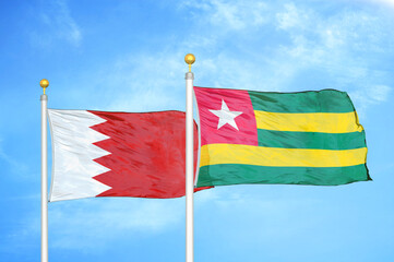 Bahrain and Togo two flags on flagpoles and blue sky