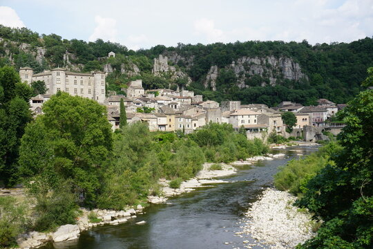 panoramic view of an old stone village and castle by the river in france